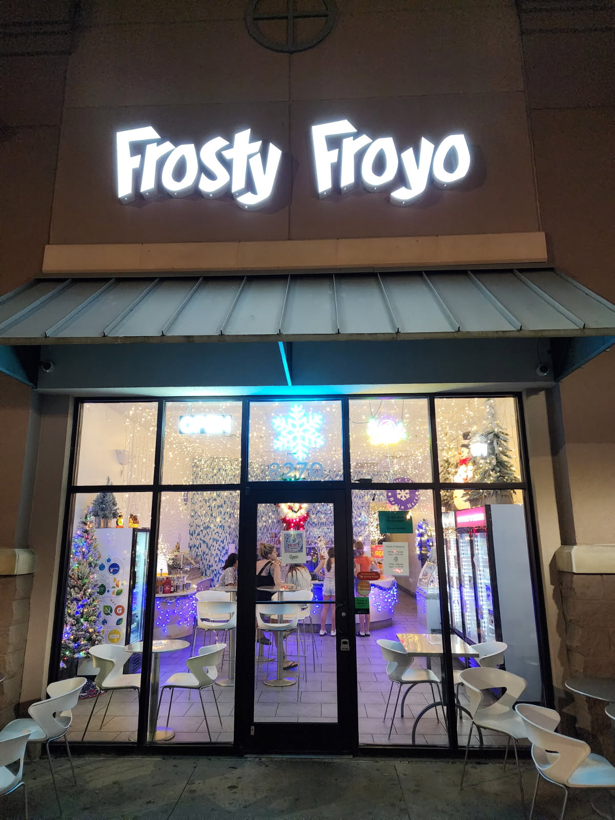 Frosty Froyo illuminated storefront at night in Champions Gate near Disney World showing festive holiday decorations